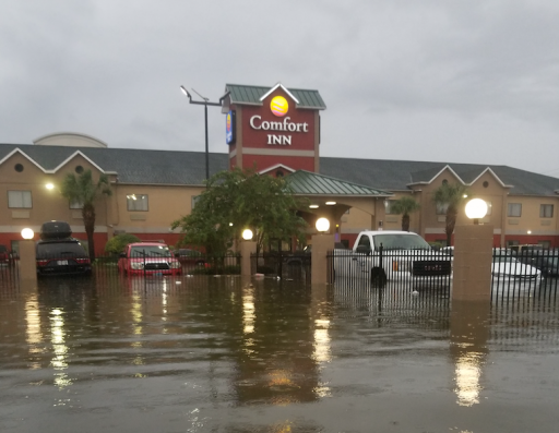 Floodwaters surround cars and the Comfort Inn, Cleveland Texas